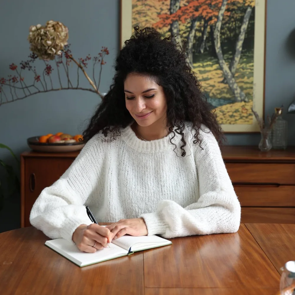 Shimona maakt aan tafel aantekeningen tijdens een opruimsessie